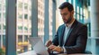 © yj - Busy professional business man employee, young male executive, entrepreneur wearing suit typing on laptop computer working at office coworking near big window.