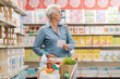 © StockPhotoPro - Confused elderly woman buying groceries at the supermarket