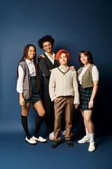 Canvas Print - Young multicultural friends, including a nonbinary person, stand together in stylish attire against a dark blue background.