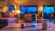 © Emiliia - A smart speaker sits on a coffee table in a living room with a couch in the background. The room is lit with warm light, and the window shows a view of the night sky.