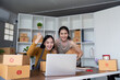 © Natee Meepian - Friends Celebrating Online Sales Success with Winning Achievement in Modern Home Office Setting