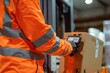 © Victoriia - A warehouse worker in high visibility clothing scans a package in a logistics center, ensuring efficient and accurate inventory management.