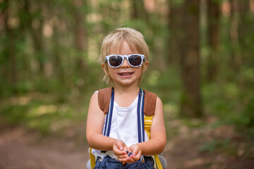 Sticker - Toddler blond child, eating wild blueberries in forest