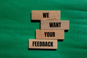 Wall Mural - We want your feedback message written on wooden blocks with green background. Conceptual we want your feedback symbol. Copy space.