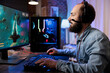 © DC Studio - Gamer playing classic arcade space shooter videogame, shooting asteroid using lazer beams. Man relaxing at home using high tech gaming PC to solve missions in singleplayer game