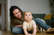 © ADDICTIVE STOCK - Caucasian mother playing with her baby on home floor