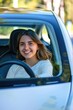 © Fotograf - A woman sits in the driver's seat of a car, ready to drive