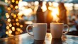 © IYearDesign - Coffee and a Good Conversation, Two coffee mugs placed next to each other on a table with a blurred background of two people talking Casual attire like a blazer or a blouse