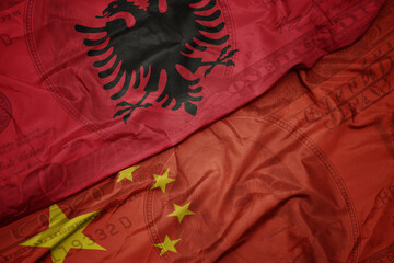 Wall Mural - waving colorful flag of albania and national flag of china on the dollar money background. finance concept.