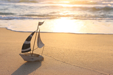 Wall Mural - Small vintage boat on beach at summer sunset