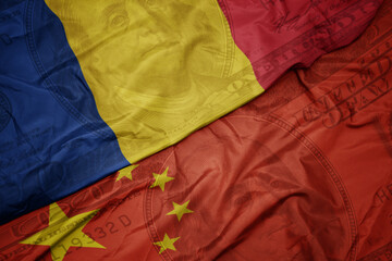 Wall Mural - waving colorful flag of romania and national flag of china on the dollar money background. finance concept.