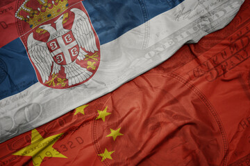 Wall Mural - waving colorful flag of serbia and national flag of china on the dollar money background. finance concept.