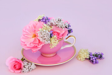 Wall Mural - Surreal rose, elder, valerian and lavender flowers in tea cup on pink. Fun food medicinal herbal medicine design. Flowers and herbs have adaptogen relaxation health benefits.
