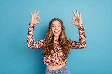 Photo of nice young girl demonstrate okey wear top isolated on blue color background