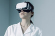 © larrui - Woman wearing VR headset and white lab coat looking up on light blue background. Studio portrait photography. Virtual reality and technology concept