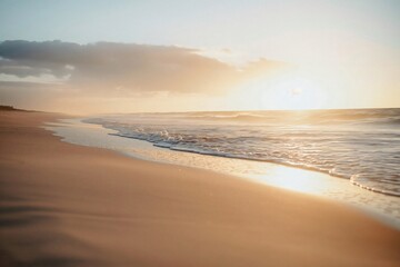 Wall Mural - Tranquil golden hour scene with gentle waves and warm sunlight washing over a pristine sandy beach