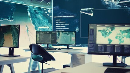 Empty military drone control center equipped with a big screen to receive alerts, satellite radar footage running on high tech equipment. Federal armed forces headquarters secret services.
