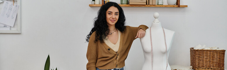 Wall Mural - Young woman upcycles clothes next to mannequin in room.