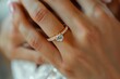 © aicandy - A close-up of a hand adorned with a delicate and elegant diamond engagement ring set in a gold band, showcasing intricate design details and craftsmanship