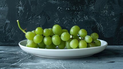 Wall Mural - Fresh green grapes on a white plate against a dark black gray art background