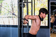 © Jack Tamrong - Shirtless strong fitness man doing exercise with gym equipment in sport club