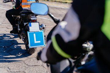 Wall Mural - A man is riding a motorcycle with a blue plate with letter L