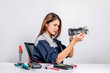 © Pituk - Beautiful young repair engineer holds the electronic circuit board of a computer with a gray background. Female technician repairing a computer