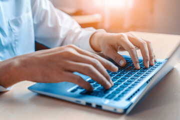 Wall Mural - businessman hand typing on computer keyboard of a laptop computer in office. business and finance co