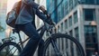 © alauli - Close up view of a businessman wearing a neat suit and tie going to work by bicycle through the city streets. Background of tall urban office buildings.