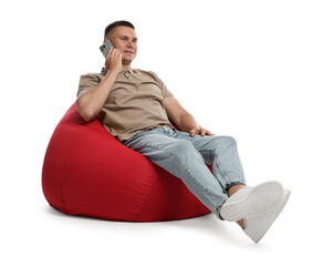 Wall Mural - Handsome man talking by smartphone on red bean bag chair against white background
