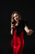 © New Africa - Beautiful young woman in stylish dress with microphone singing on black background