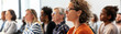 © artitwpd - A group of diverse professionals are sitting in a conference room listening to a presentation