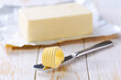 © Igor Dudchak - Tasty butter and knife on a kitchen table, selective focus. Butter curl on knife .
