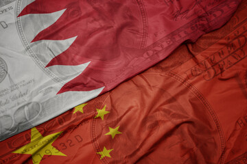 Wall Mural - waving colorful flag of bahrain and national flag of china on the dollar money background. finance concept.