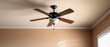 © May Chanikran - Modern ceiling fan with wooden blades and light fixture mounted on a beige ceiling, providing comfort and style to a home interior.