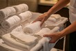 © pham - A hotel room service attendant prepares a stack of fresh, white towels for a room