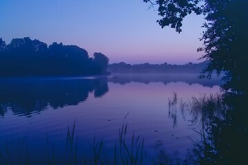 Wall Mural - A serene lake at dawn, the watera??s surface aglow with the first light of day