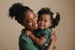 © MD Media - A beautiful African American mother cuddles her baby girl laughing and playing with his daughter