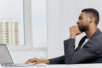 Wall Mural - Business professional focused on work, analyzing data on a laptop at a modern office desk