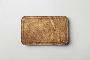 a worn leather patch with stitched edges against a white background