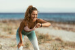 © milanmarkovic78 - Woman Checking Smartwatch During a Morning Run On The Beach