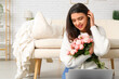 © Pixel-Shot - Young woman with roses and laptop video chatting on online date at home