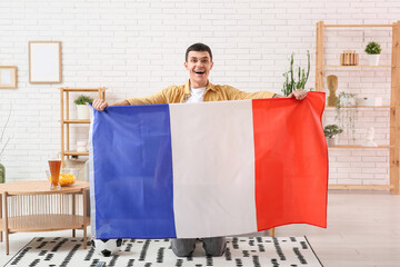 Wall Mural - Young man with soccer ball and flag of France at home