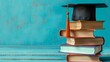 © Ziyan Yang - Graduation day.A mortarboard and graduation scroll on stack of books with blue background.Education learning concept.