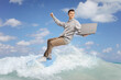 © Ljupco Smokovski - Male teenager surfing on a wave and holding a laptop computer