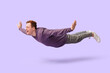 © Pixel-Shot - Joyful young man flying on lilac background