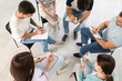 © Pixel-Shot - Young people writing in clipboards at group therapy session, top view