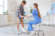 © Pixel-Shot - Injured little boy with crutches and doctor in clinic