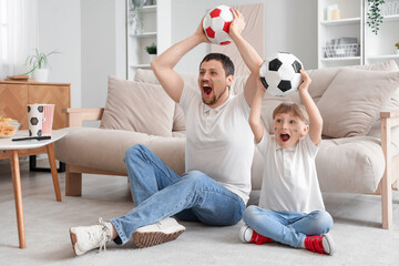 Sticker - Young father and little son with soccer balls sitting on floor at home