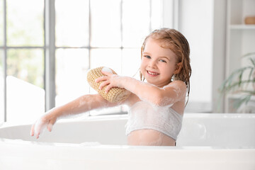 Wall Mural - Cute little girl with sponge taking bath in bathroom